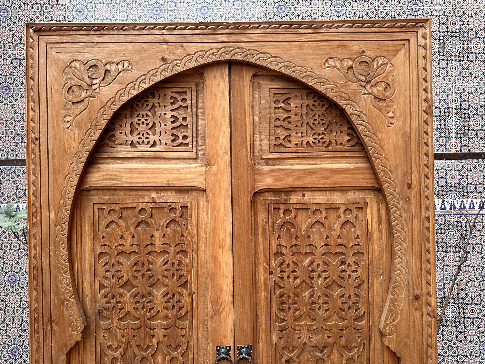 Light wood bedroom door, carved with wavy patterns, creating a calming and serene atmosphere.