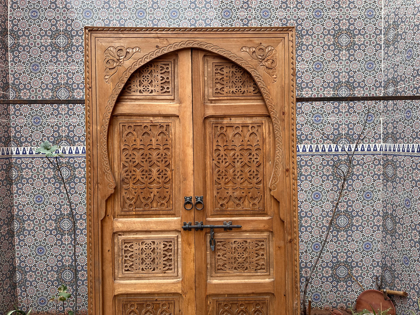 Solid wood pivot door, carved with bold geometric patterns, creating a focal point in your room.