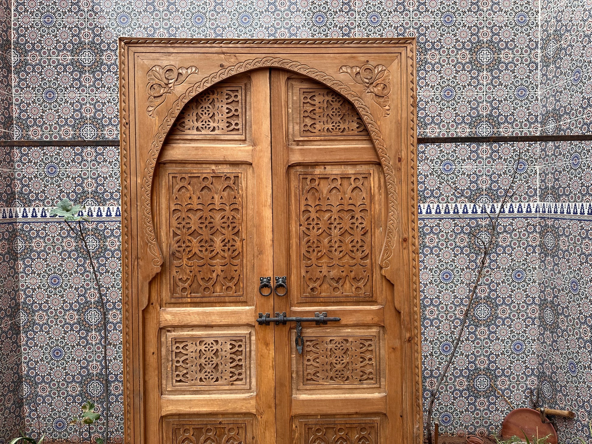 Solid wood pivot door, carved with bold geometric patterns, creating a focal point in your room.