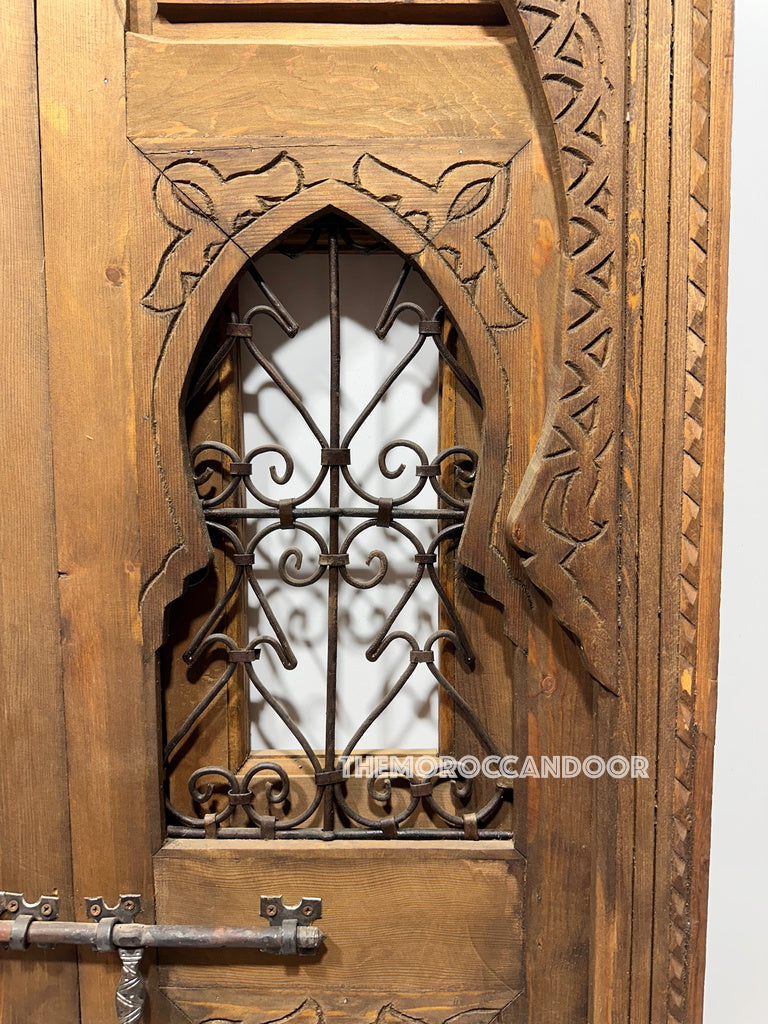 Hand-carved Moroccan door as a decorative room divider creating a separation in a living area