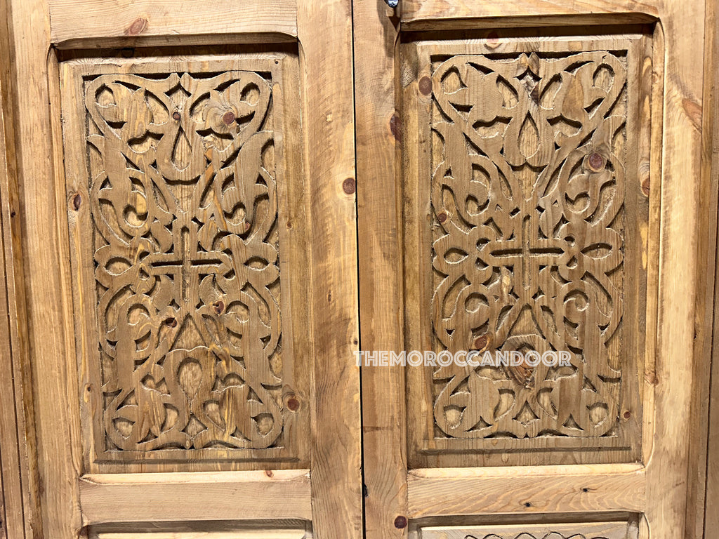Hand-carved Moroccan door with natural wax finish, highlighting the wood grain and texture. (Highlights the natural finish and wood characteristics)