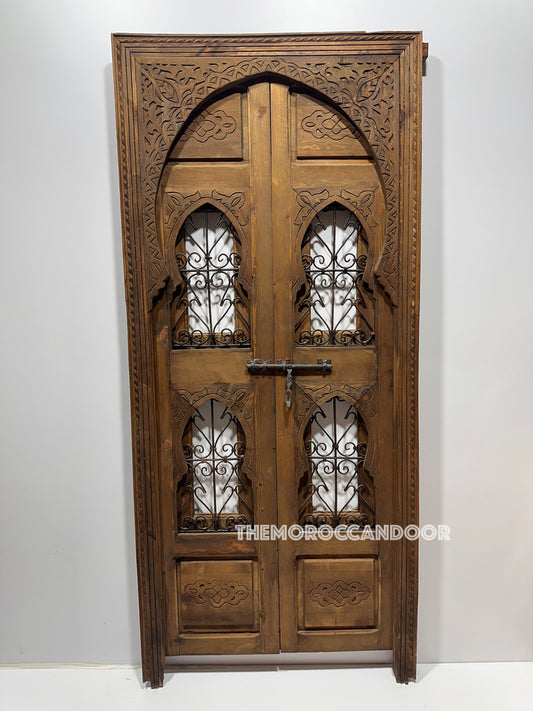 Hand-carved Moroccan door with detailed geometric patterns in natural cedar wood.