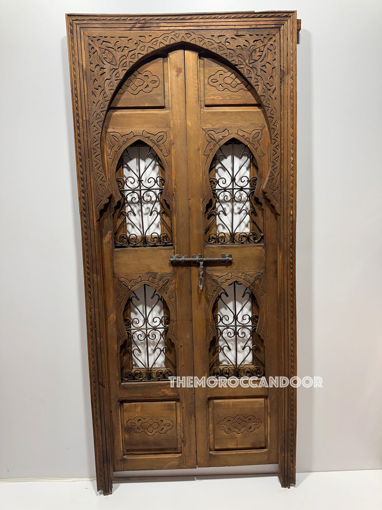 Lifestyle shot of a person gazing through the door, creating a sense of mystery and intrigue.   Hand-carved Moroccan door creating a captivating entranceway, hinting at a glimpse into a beautiful space.