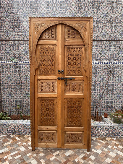 Light wood interior door, carved with subtle patterns, blending seamlessly with any type of decor.\